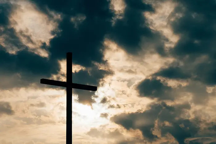 Cross with clouds behind it